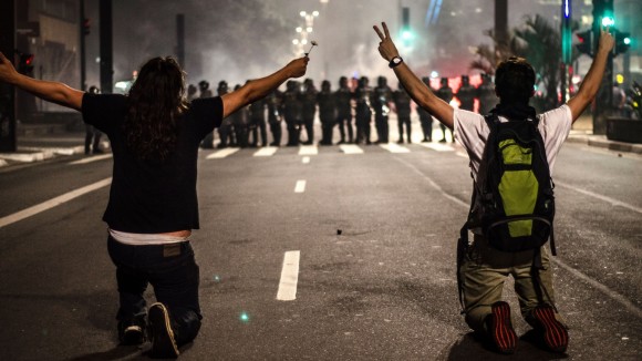 11jun2013-manifestantes-se-ajoelham-diante-de-pms-durante-protesto-na-avenida-paulista-em-sao-paulo-o-homem-da-esquerda-foi-atingido-por-uma-bala-de-borracha-na-sequencia-1371005432910