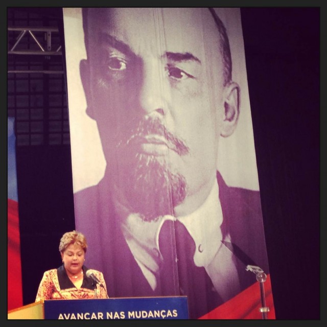 Dilma discursando com a imagem de Lenin atrás