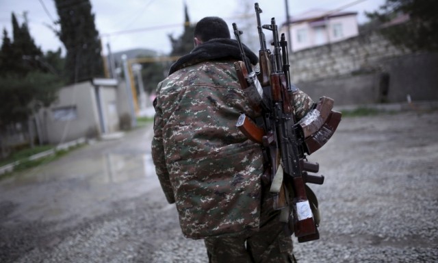 A soldier of the self-defense army of Nagorno-Karabakh carries weapons in Martakert province, which according to Armenian media was affected by clashes over the breakaway Nagorno-Karabakh region, April 4, 2016. REUTERS/Vahan Stepanyan/PAN Photo