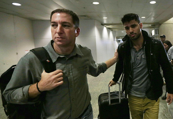 O jornalista americano Glenn Greenwald (à esq.) e o namorado dele, David Miranda, no aeroporto do Rio, no domingo