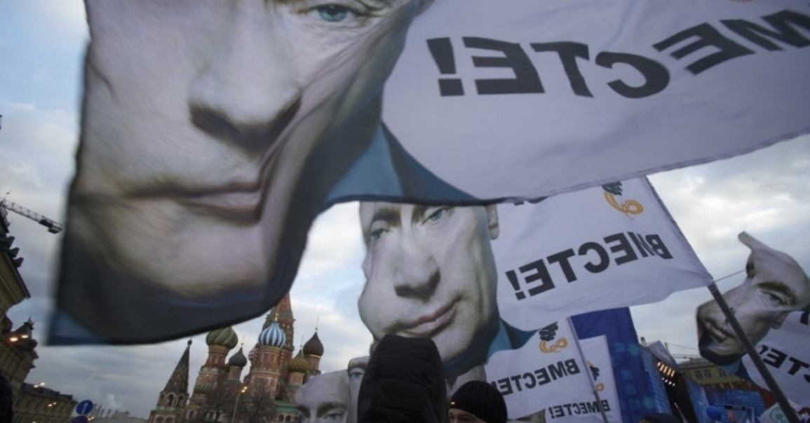 Multidão realiza passeta em apoio à anexação da Crimeia a Rússia com faixas que mostram o presidente russo Vladimir Putin na praça Vermelha em Moscou FOTO  Pavel Golovkin AP