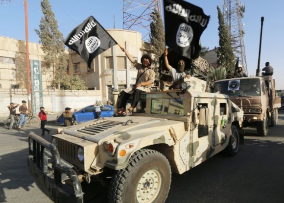 Militant Islamist fighters take part in a military parade along the streets of Syria's northern Raqqa province