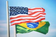 Flag of the USA and Brazil against the background of the blue sky